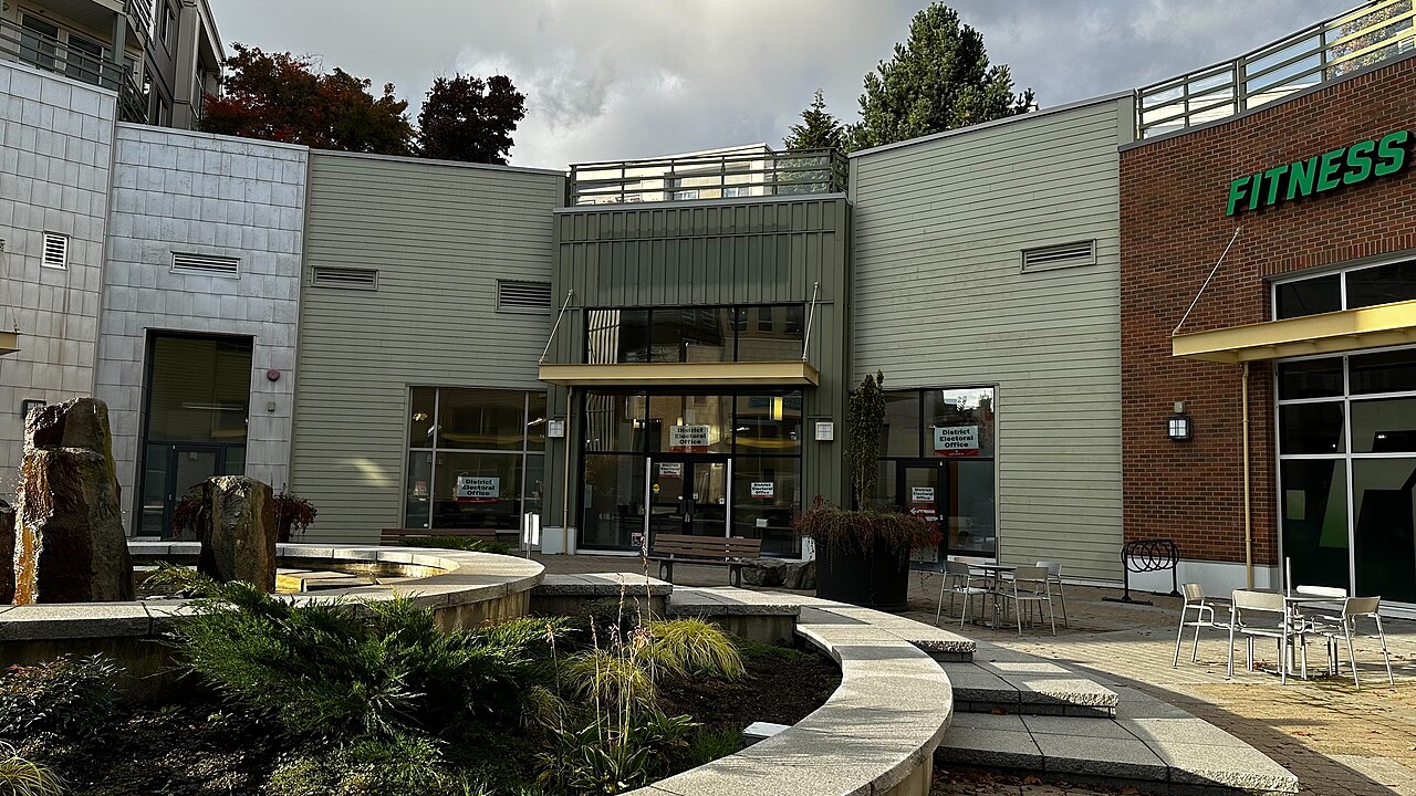 Exterior of a B.C. provincial district electoral office in Surrey, with election signs on its windows and entrance