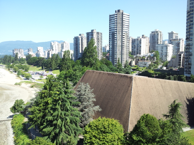 The Vancouver Aquatic Centre’s sloping roof beside Sunset Beach, with West End towers behind it