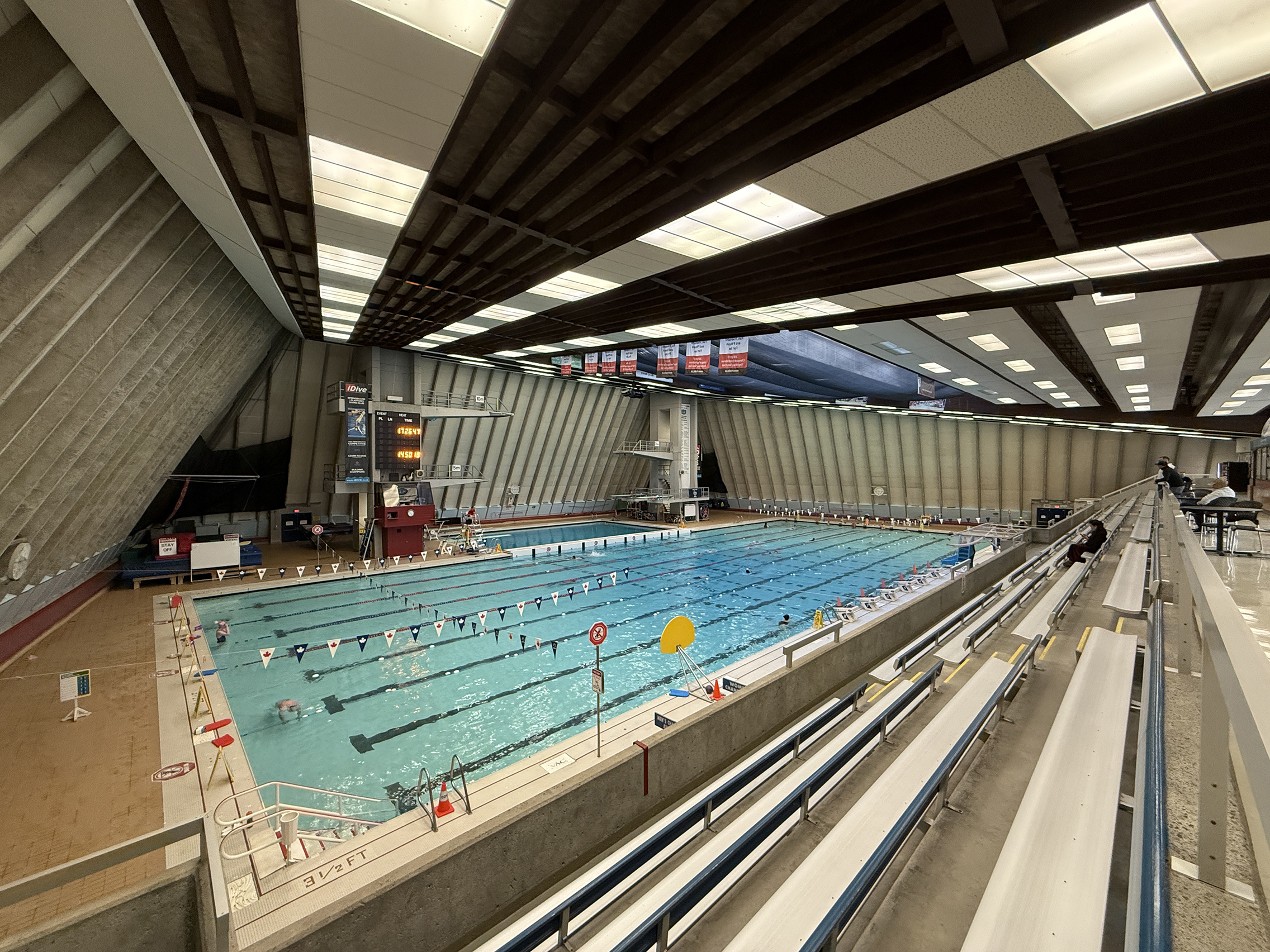 Lap lanes and diving platforms inside the Vancouver Aquatic Centre, seen from the spectator seating